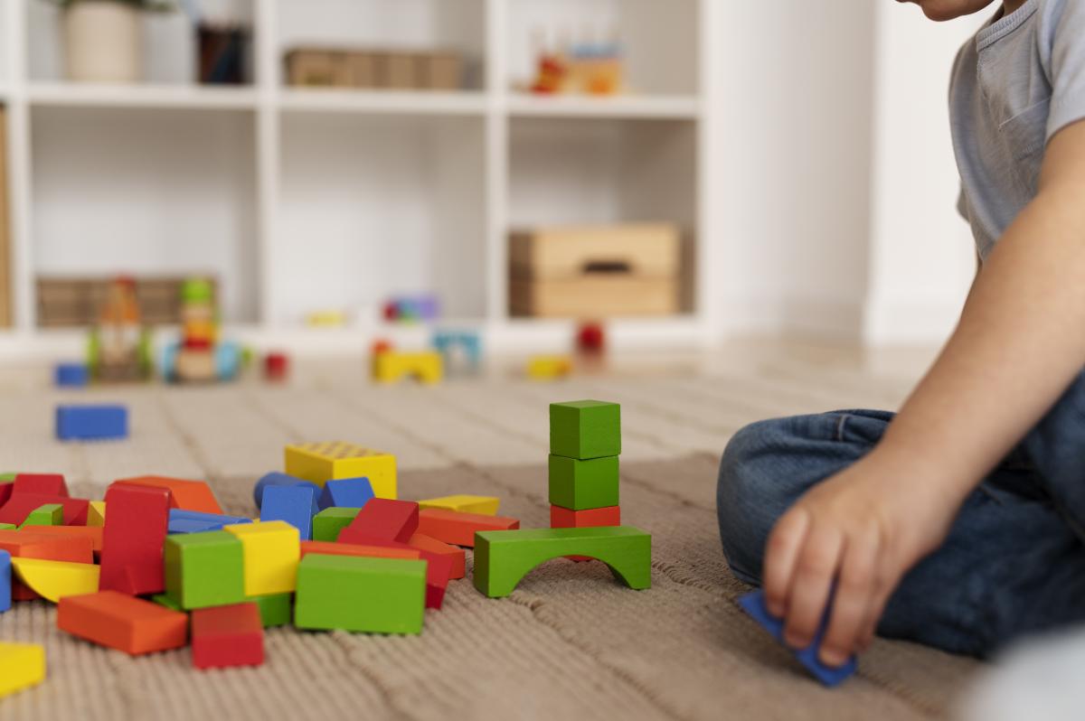 Niño lindo jugando con juguetes de madera